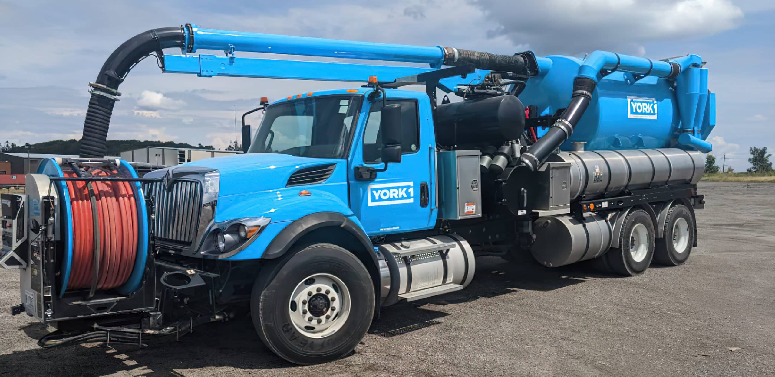 Cyan York1 hydro excavation truck parked on asphalt under a blue sky with a few clouds