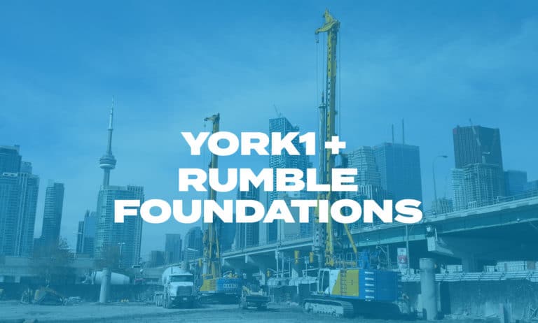 Two hydraulic rigs completing a shoring job with the CN tower and skyscrapers in the background. Photo with blue overlay, York1 + Rumble in white text.