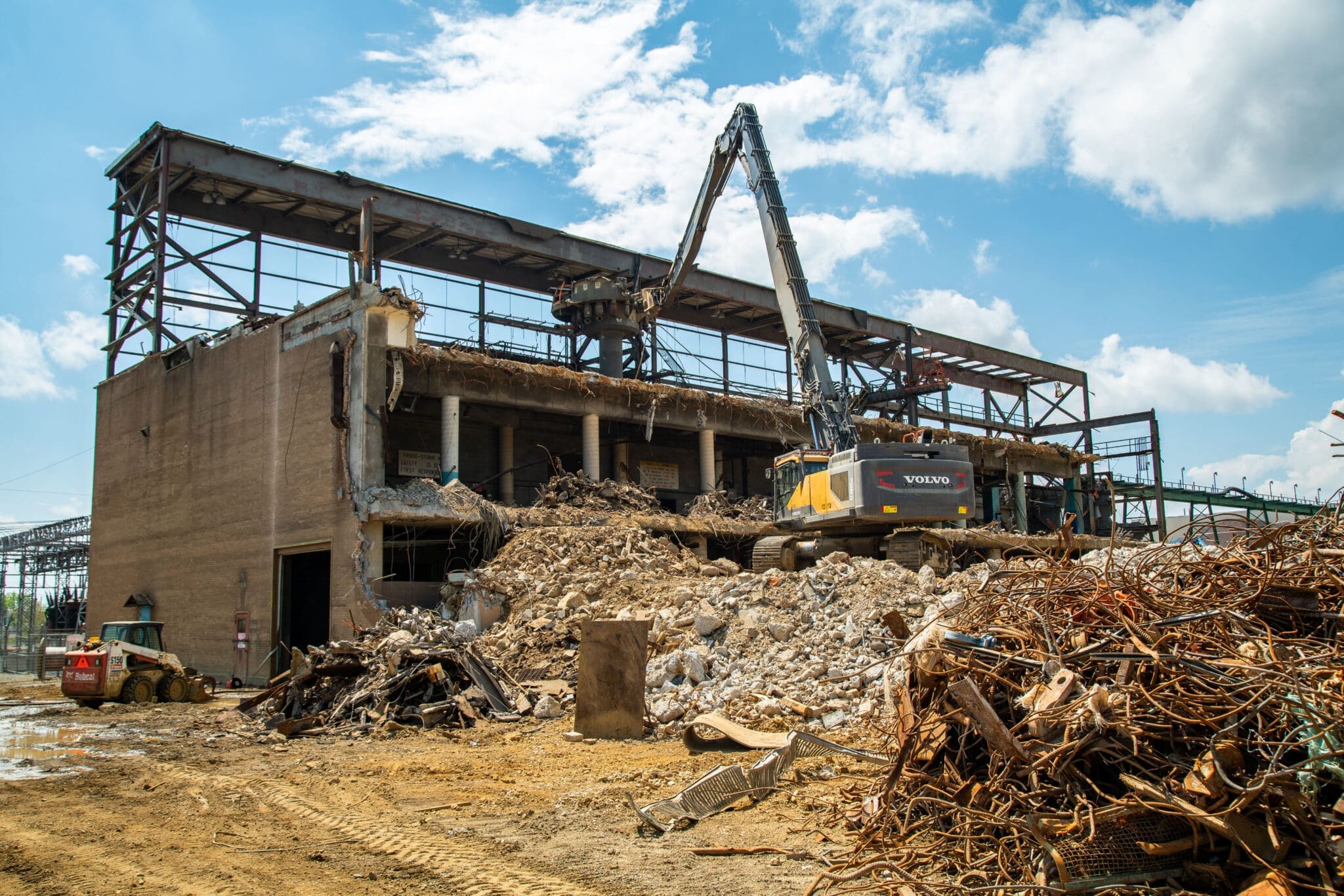 Mill demolition project and metal asset recovery featuring a high reach machine dismantling the top of the mill