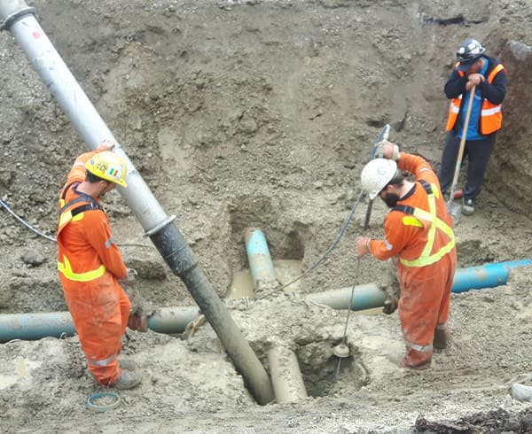 "Skilled workers installing water main and force main pipes with precision and expertise.