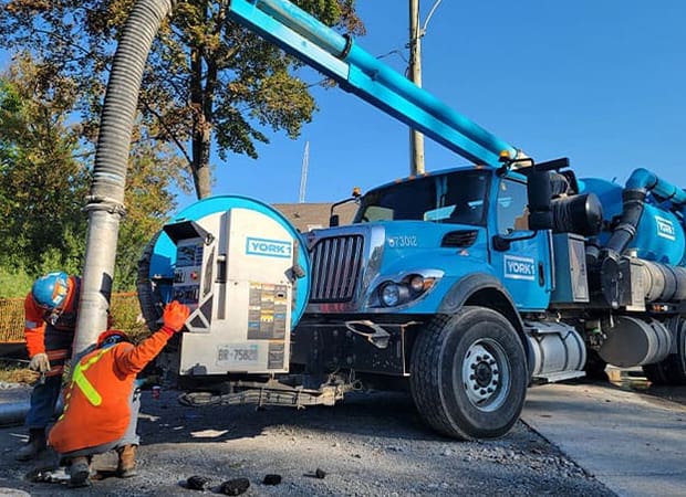 Blue Hydrovac Truck, Two Workers in full PPE