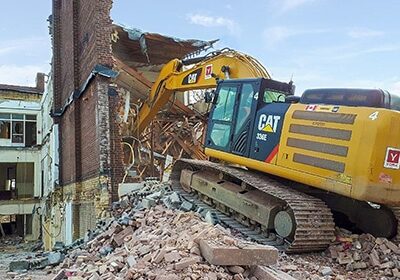 Yellow York1 excavator on a pile of building debris, completing a building demolition