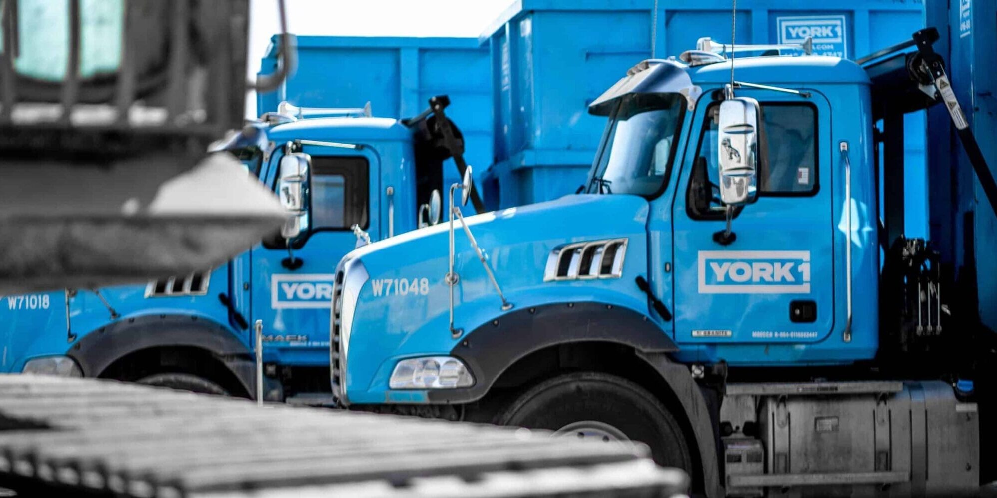 a line up of YORK1 roll off trucks