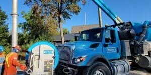 Hydrovac sewer flushing equipment clearing debris from underground pipes.