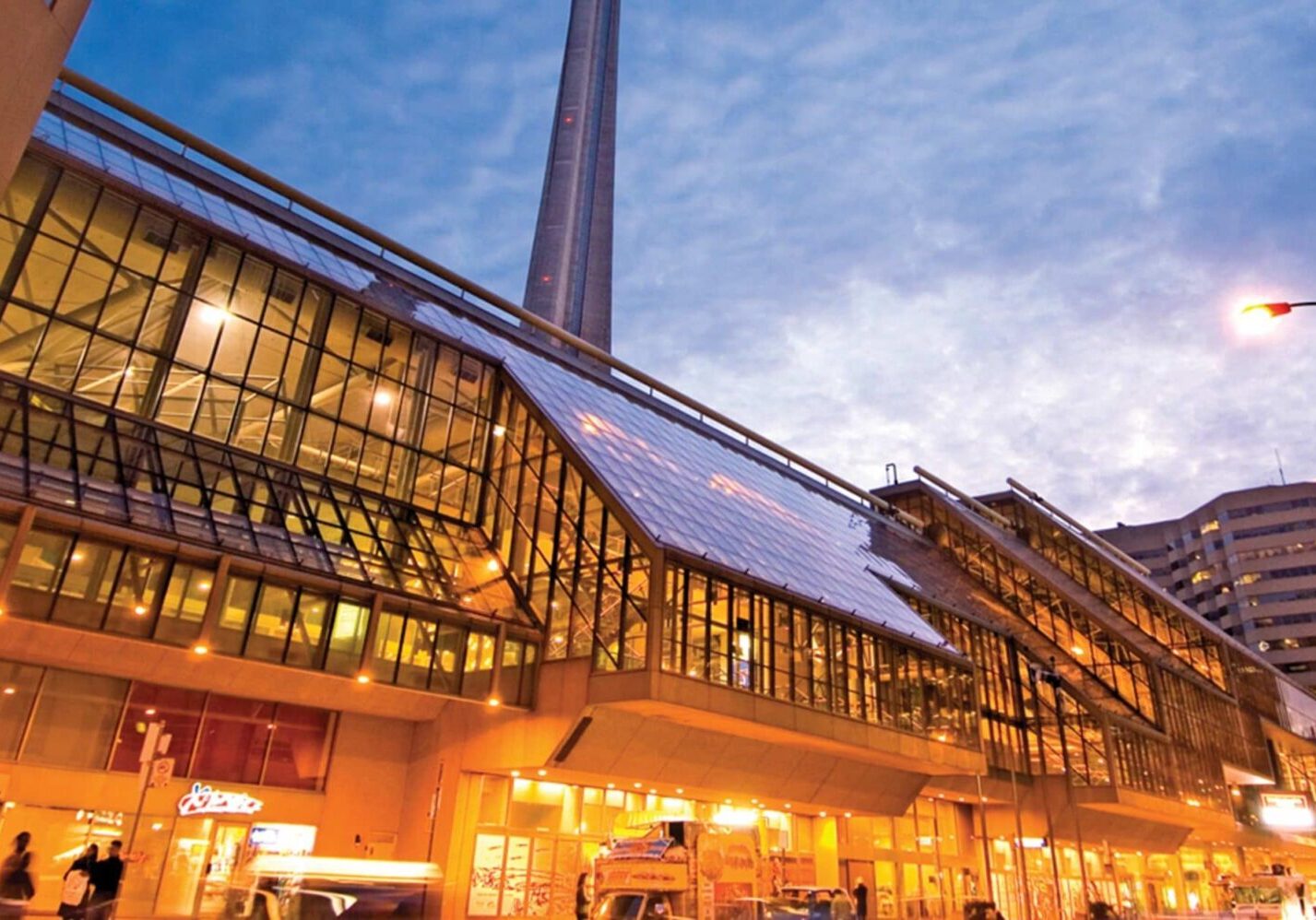 Exterior side view of the Metro Toronto Convention Centre at sunset. CN Tower in the background.