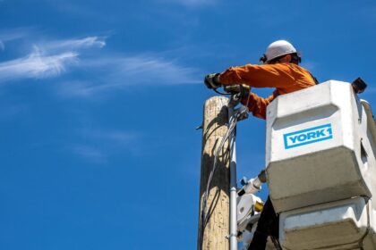 An employee of performing aerial utility work at height